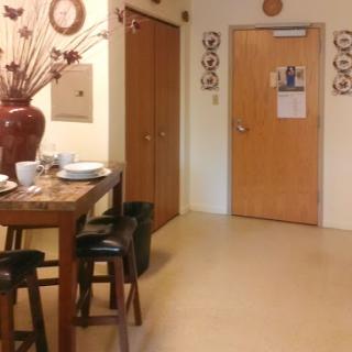 A cozy dining area featuring a wooden table set for a meal, accompanied by decorative elements on the walls.