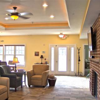 A cozy living room with comfortable seating, a ceiling fan, and a fireplace.