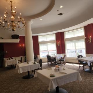 An elegant restaurant dining room featuring a chandelier and several tables.