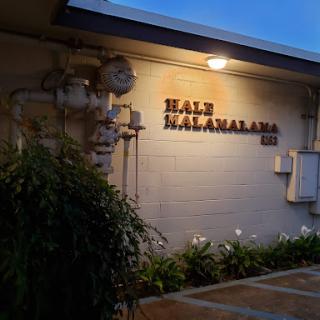 Night view of the Hale Kahalana building, showcasing its illuminated sign.