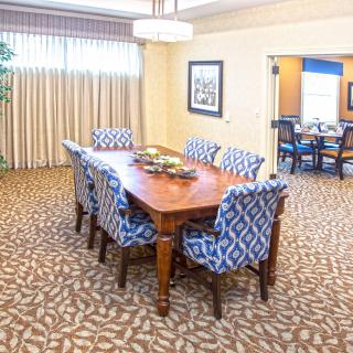 A well-decorated dining room with a wooden table and patterned chairs.
