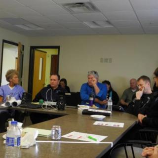 A group of people in a meeting around a conference table.
