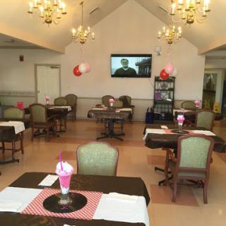 A cozy dining area featuring elegantly set tables, decorative lights, and a television for entertainment.