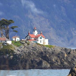 A scenic view of a lighthouse perched on a rocky coastline.