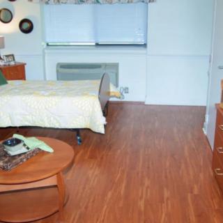 A cozy bedroom with wooden flooring and simple decor.