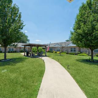 A scenic garden path leads to a pavilion surrounded by greenery.