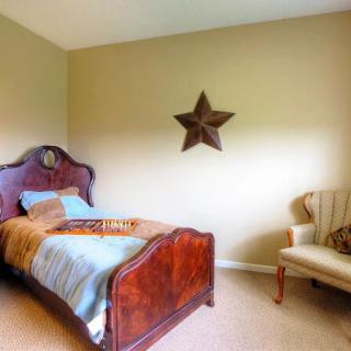 A cozy bedroom featuring a single wooden bed and decorative star on the wall.