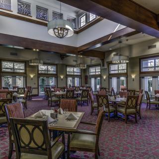 A spacious dining area with elegant furniture and ample natural lighting.