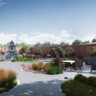 A beautifully landscaped garden featuring a fountain, pathways, and outdoor seating areas.