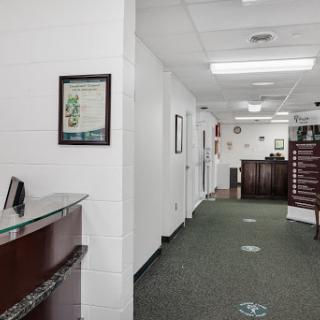 A view of a modern office lobby with a reception desk and hallway.