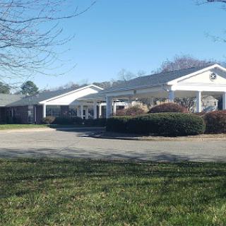 A sunny day showcasing a well-maintained residential building surrounded by lush greenery.