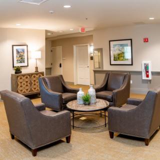 A cozy seating area with four chairs arranged around a coffee table in a lobby.