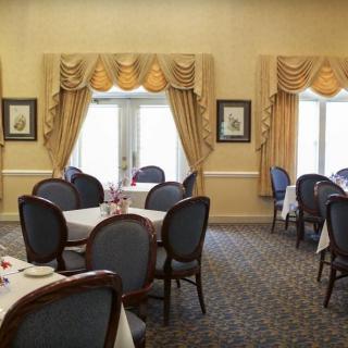 An elegant dining room with neatly arranged tables and decorative curtains.