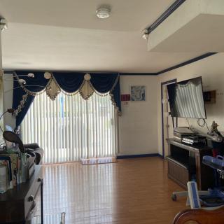 A spacious living room with large blue curtains and a television setup.