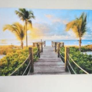 A picturesque boardwalk leading to a tropical beach at sunset.