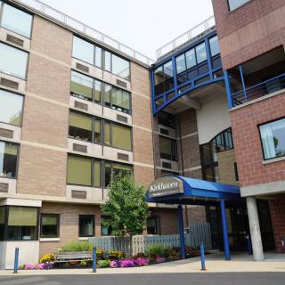 The exterior view of a hospital building with a clear entrance and multiple windows.