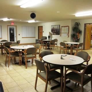 An empty community dining area with round tables and chairs.
