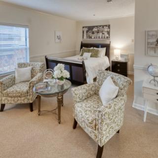 A cozy bedroom with floral-patterned chairs and elegant decor.