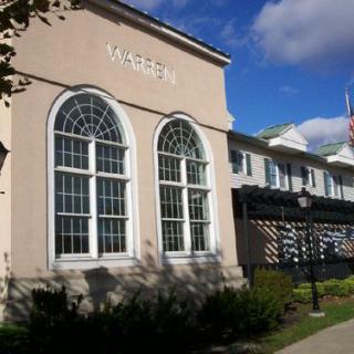 A building exterior with large arched windows and a clear blue sky.