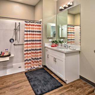 A modern bathroom with a colorful shower curtain and sleek vanity.