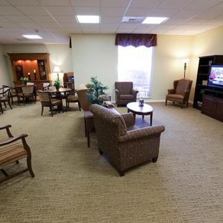 A cozy living room with comfortable seating, a television, and warm lighting.