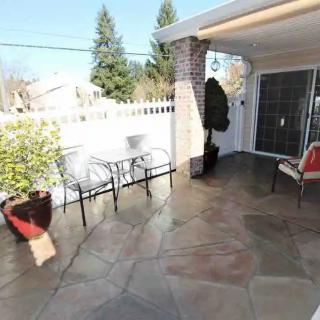 A sunny patio with seating, a small table, and potted plants.