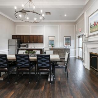 A modern dining area with a wooden table, stylish chairs, and an open kitchen layout.