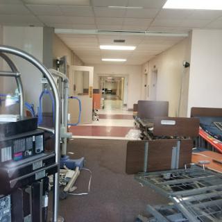 A view of a hospital corridor undergoing renovation, with furniture and equipment scattered throughout.