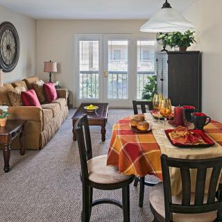 A cozy living and dining area with a comfortable sofa and a colorful table setting.