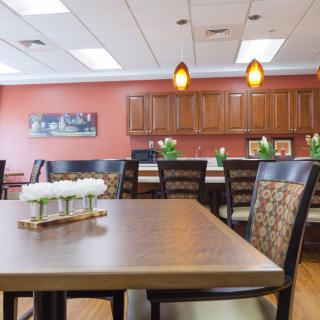 A modern dining room with a wooden table, chairs, and pendant lighting.