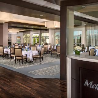 A sophisticated dining area with elegantly set tables and large windows.