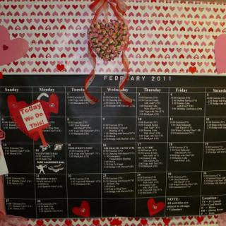 A February calendar adorned with Valentine's Day decorations, featuring a heart-themed background and detailed daily schedule.