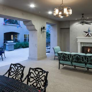 A cozy outdoor patio featuring a fireplace, comfortable seating, and elegant lighting.