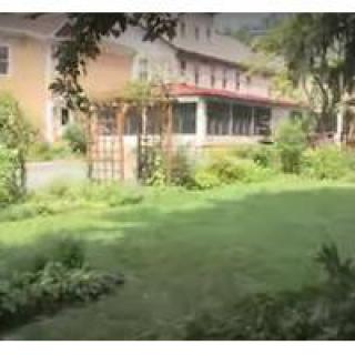A lush garden in front of a large building.