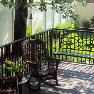 A tranquil outdoor deck with wicker chairs and a view of the garden.