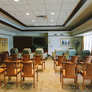 An empty conference room with rows of chairs arranged for a meeting.