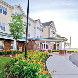 A charming residential building with well-maintained landscaping and colorful flowers at the entrance.