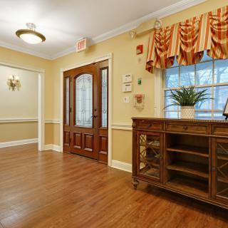 A welcoming entryway featuring wooden floors and elegant furnishings.