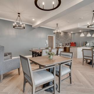 A modern dining area with elegant chandeliers and an open kitchen space.