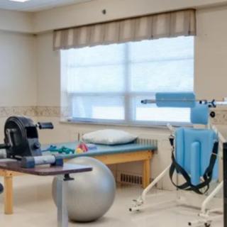 A physical therapy room equipped with various rehabilitation devices and exercise equipment.