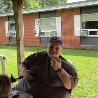 A person enjoying a snack outdoors on a sunny day.