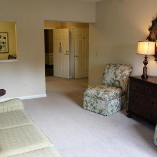A cozy living room with a sofa, armchair, and lamp.