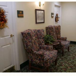 A hallway with patterned chairs and wall decor.