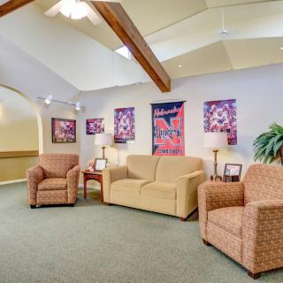 A cozy waiting room featuring comfortable seating, colorful artwork, and warm lighting.