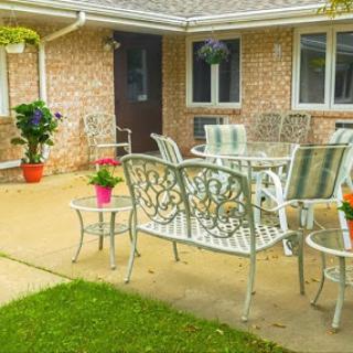 A cozy outdoor patio setup with metal furniture and vibrant potted plants.