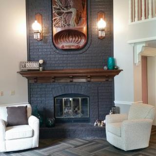 A modern living room with a brick fireplace and cozy seating.