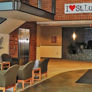 A hospital lobby with seating and signage that reads 'I ? St. Luke's'.