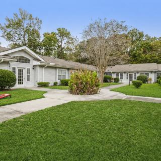 A suburban home with a well-maintained lawn and surrounding trees.