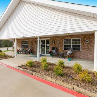 A brick building with a covered porch and landscaped front area.