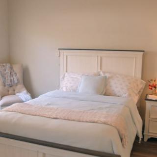 A cozy bedroom with a neatly made bed and soft lighting.